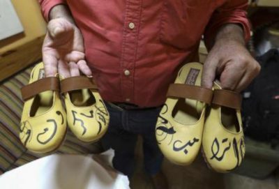 فلسطيني يختم بالخط العربي اسمي ترامب وماكرون على أحذية يصنعها يدويا (صور)